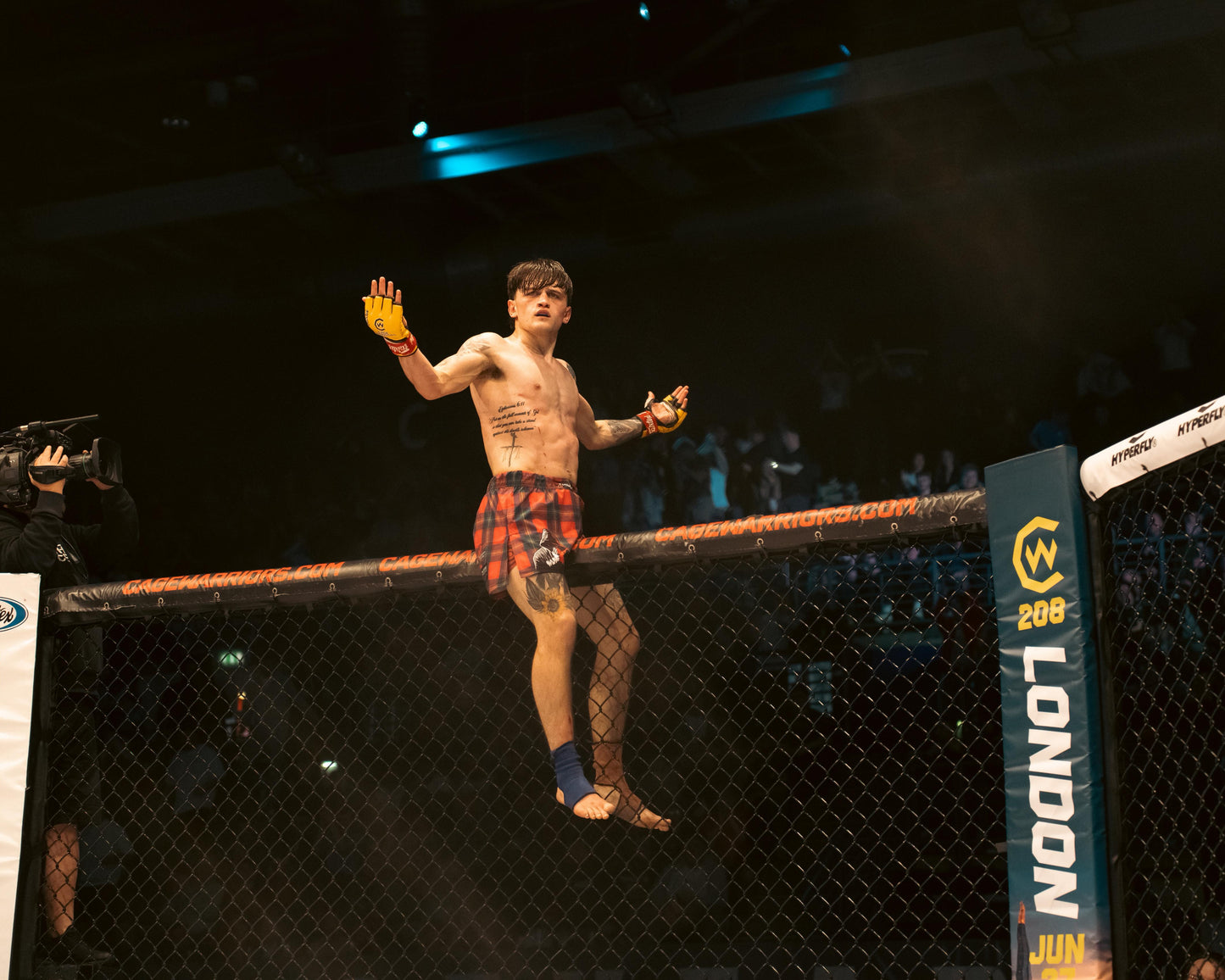 Jamie the Choirboy McGowan celebrating inside a Cage Warriors octagon with branding visible