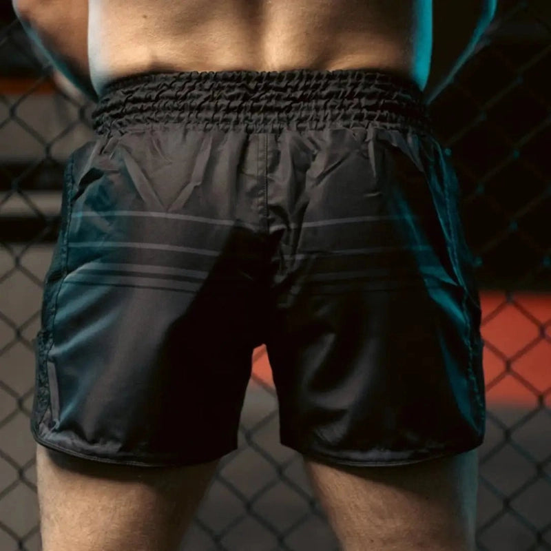 Black Muay Thai shorts back view with elastic waistband and side slits