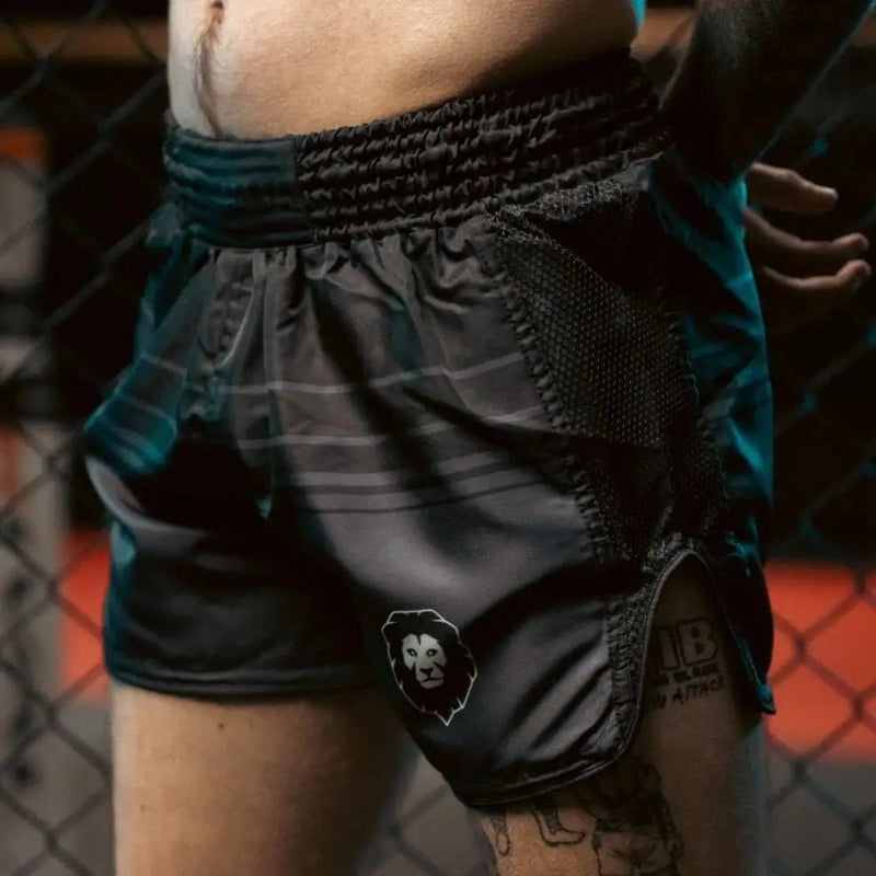 Black Muay Thai shorts side view on model showing mesh paneling