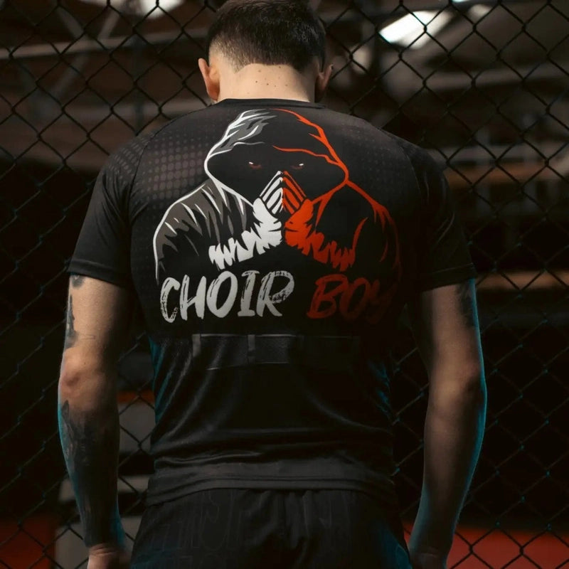 Male model wearing black Choirboy gym tee showing back graphic in caged training environment