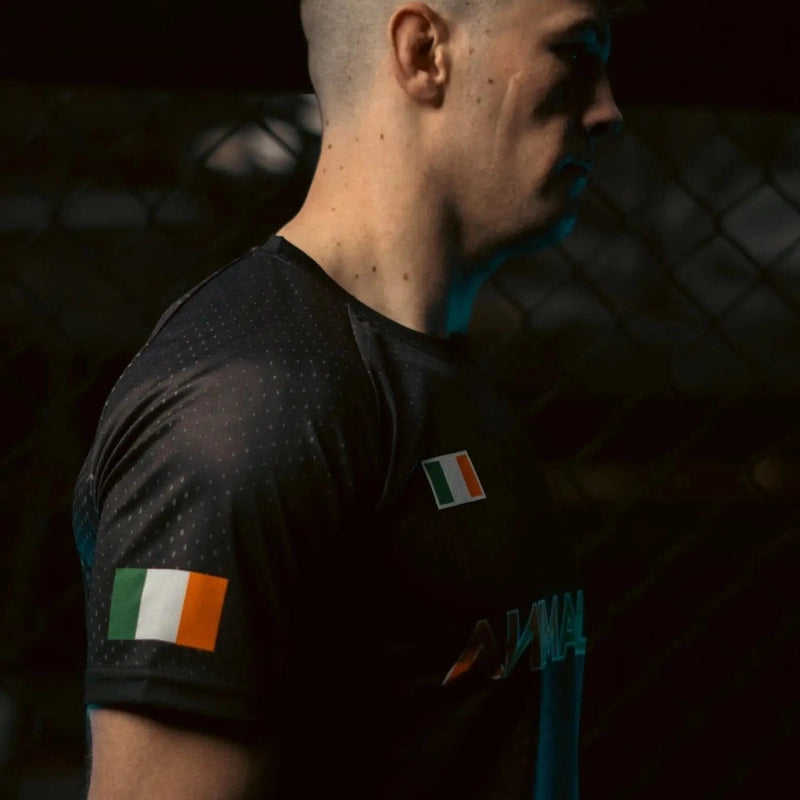 Close-up side profile of black athletic t-shirt featuring Irish flag patch on chest and sleeve