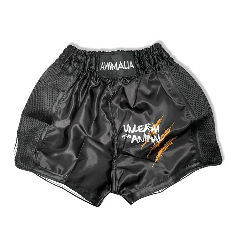 Black kids Muay Thai shorts with gold claw design and Unleash the Animal text