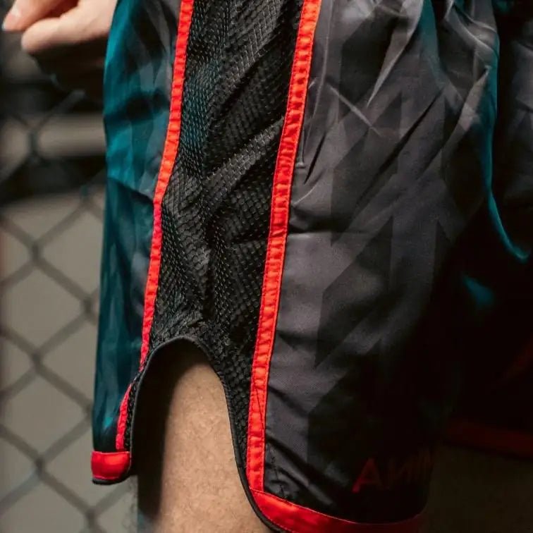 Close-up of black mesh panel and red stitching on Muay Thai shorts