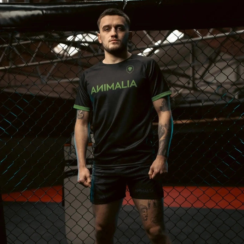 Man wearing black Animalia martial arts t-shirt in gym setting